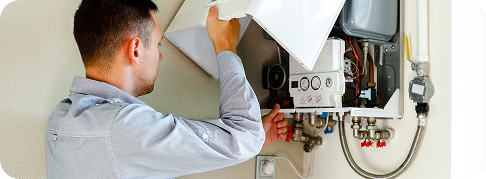 someone opens the cover of a boiler unit on a wall