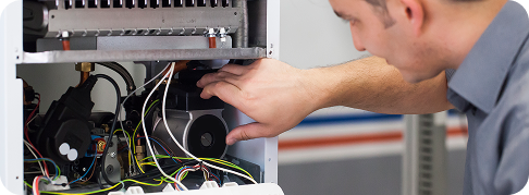 a technician works on a boiler unit on a wall