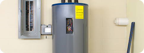 a gray modern water heater unit next to a brick wall