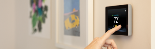 Woman adjusting a smart thermostat