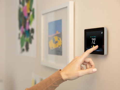 Woman adjusting a smart thermostat