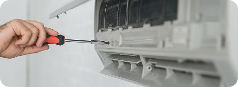 someone uses a screwdriver to tighten a screw on a ductless hvac unit