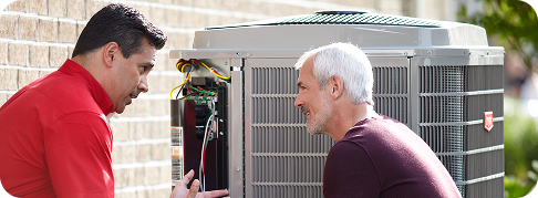 a technician speaking with a customer next to an outdoor air conditioning unit