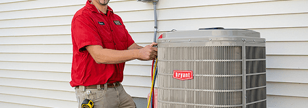Haley Comfort Systems technician servicing a Bryant air conditioning unit outside a home.