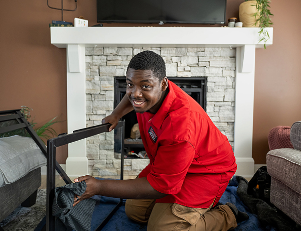 Haley Comfort Systems technician cleaning glass pane for fireplace